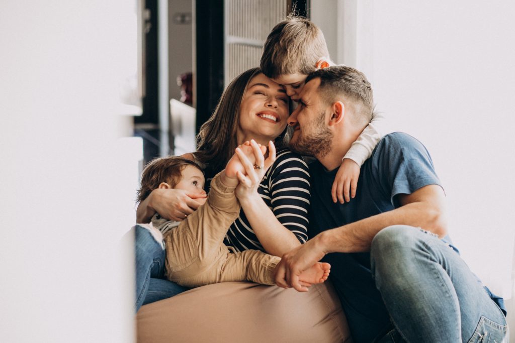 famille de 4 souriante sur un canapé