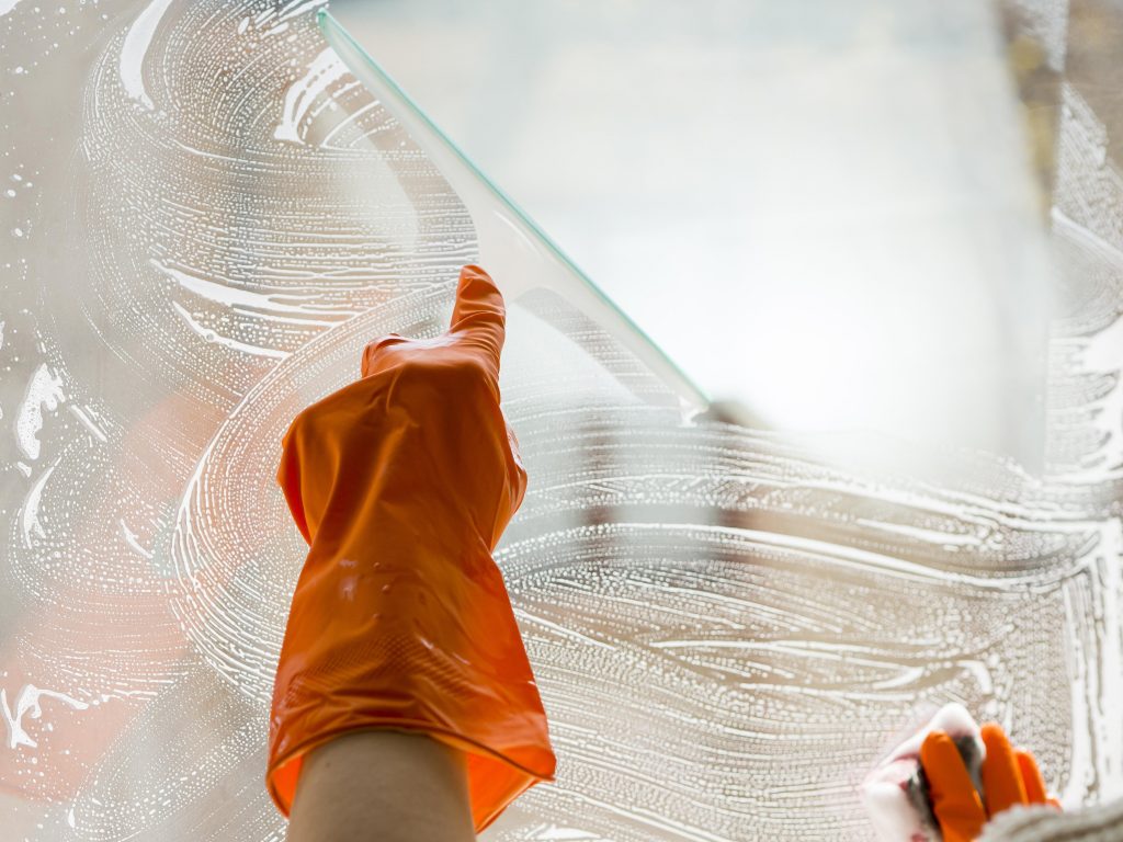 Personne avec des gants oranges qui nettoie un velux